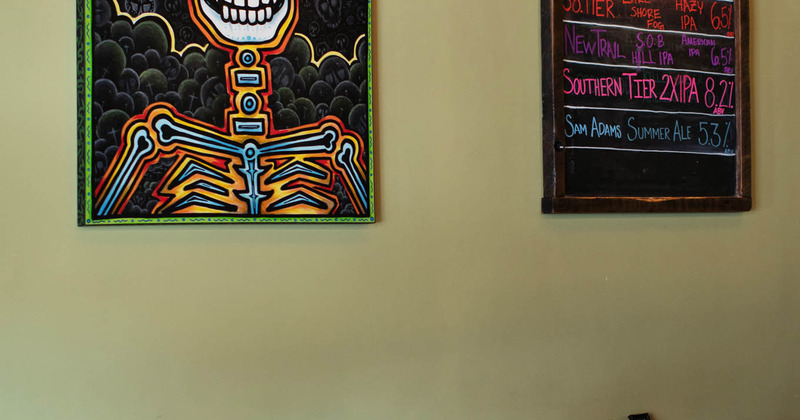 Interior wall detail, one brightly colored Mexican painting and one blackboard with the menu