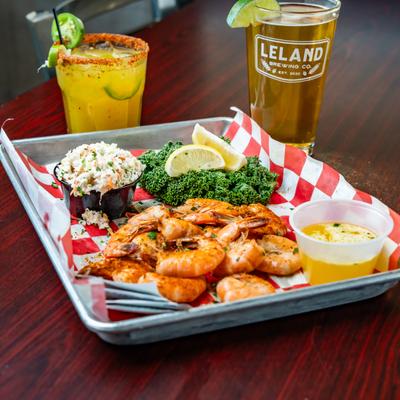 Peel And Eat Shrimp  with coleslaw and a side salad, accompanied by a cocktail and a beer.