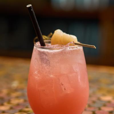 Lychee Me Alone cocktail garnished with fresh lychee fruit on a pick.