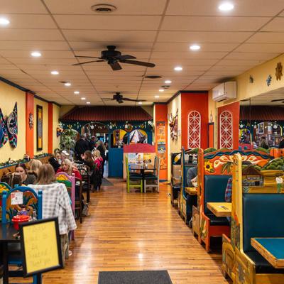 Colorful interior with booths, guests seated at tables, and wall decorations.