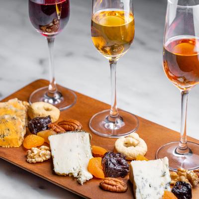 Various cheese, nuts and crackers on cutting board