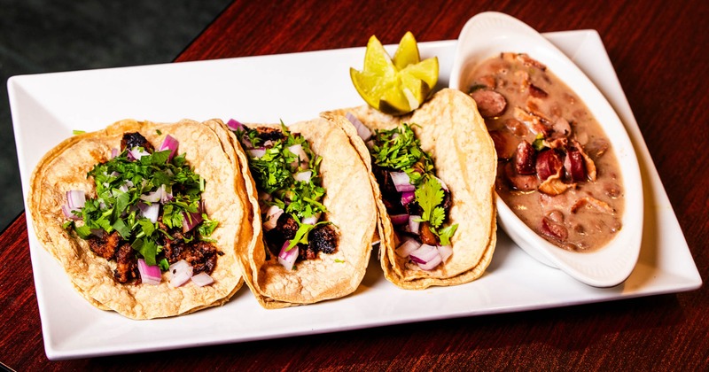 Asada tacos served alongside bean soup