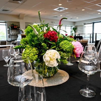 Elegant table setting with floral centerpiece and wine glasses.