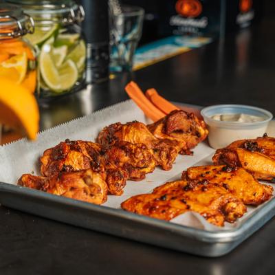 Buffalo wings with dipping sauce and carrots.