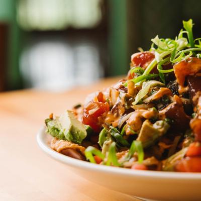 Close up view of poke nachos with sauce and green garnish.