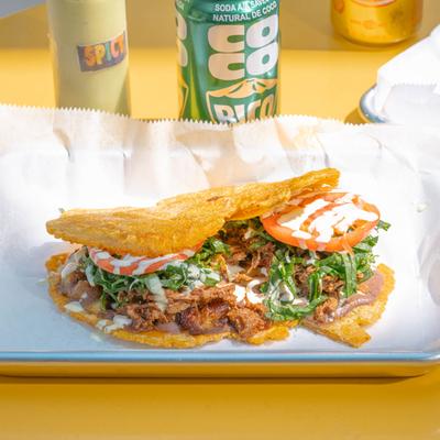 Shredded beef sandwich, with black beans, sweet plantains, tomato, and spinach.