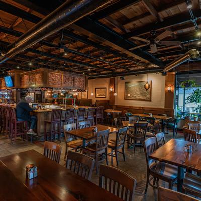 Interior with exposed ceiling beams, warm lighting, counter area and table seating.