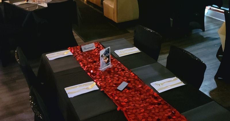 Private table covered with black tablecloth and set with cutlery