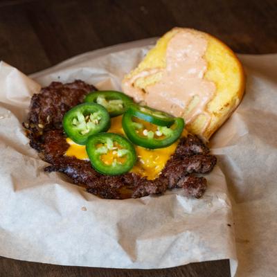 A cheeseburger with jalapenos.