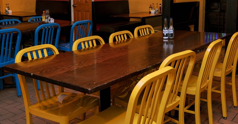 Wooden table with yellow chairs for eight guests, close up