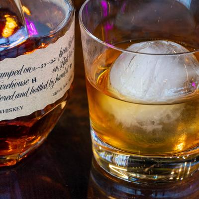 Close-up of a glass of bourbon served next to a bottle of the drink