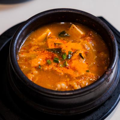Tofu soup in a black stone pot.