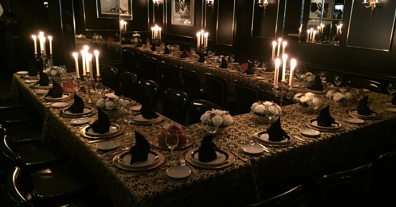 Interior, large table in u shape with candles as decoration ready for guests