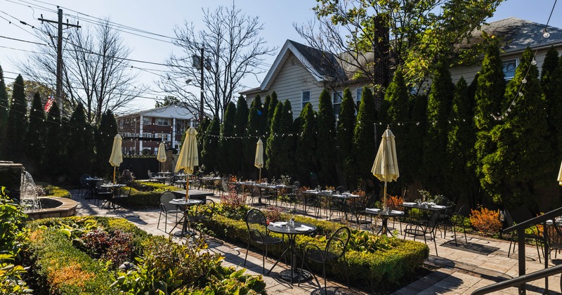 Exterior, outdoor seating area, tables and chairs, parasols, lavish plant decoration