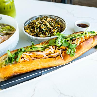 Grilled Pork Bahn Mi, brussels sprouts, and  lobster pho bowl on the table