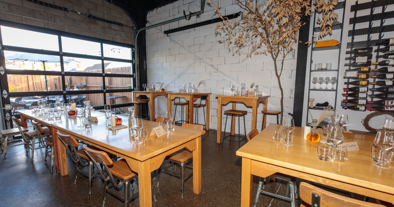 Interior with wooden tables and chairs, large window and wine bar