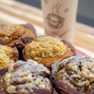 Assorted muffins with a coffee cup.
