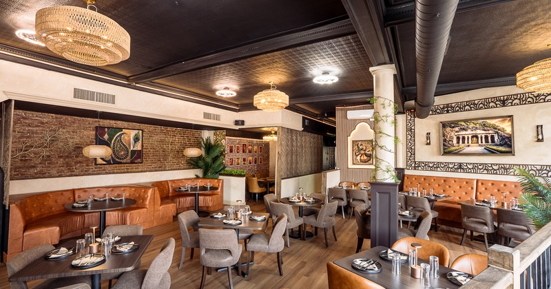 Modern and spacious interior dining area with dining tables set for guests
