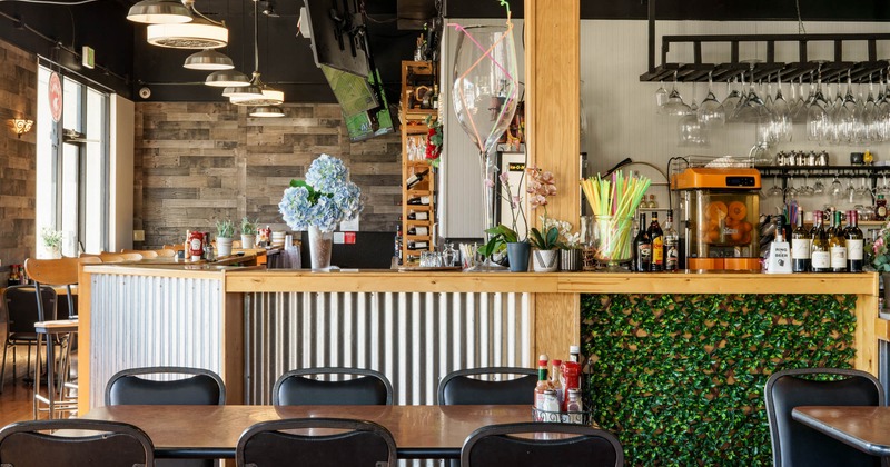Interior, bar area, wooden top bar with stools, various shelfs holding bottles and glasses
