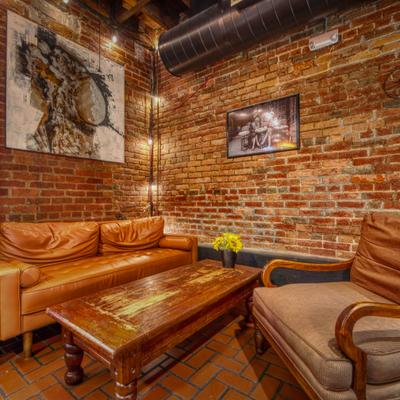 Interior with leather sofa and a matching armchair, table and framed art.