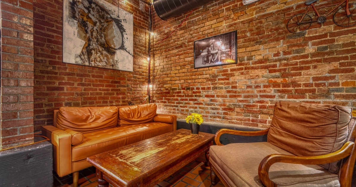 Interior with leather sofa and a matching armchair, table and framed art