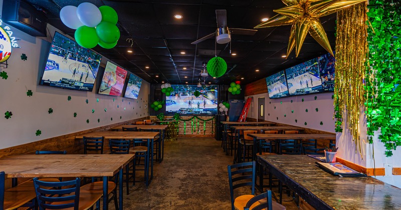 Interior of a sports bar with tables, TVs displaying a basketball game