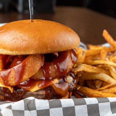 A close-up of a Western burger with fries.