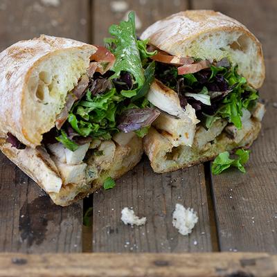 Sandwich with grilled chicken, tomatoes and greens.