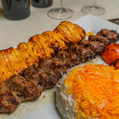 Beef and chicken kebab with saffron rice and roasted tomato.