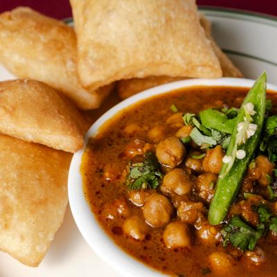 Chickpea curry served with puffy bread.