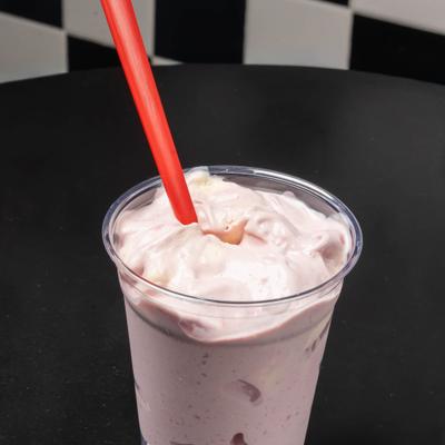 Strawberry Shake served in a plastic cup with a red straw.