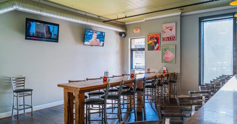 Casual dining area with a long wooden high-top table and metal bar-style chairs