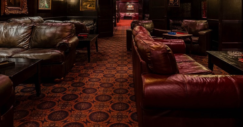 Interior, seating area, sofas and armchairs with tables, carpet flooring, framed paintings