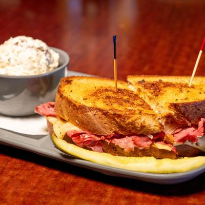 Reuben sandwich served with potato salad on the side.