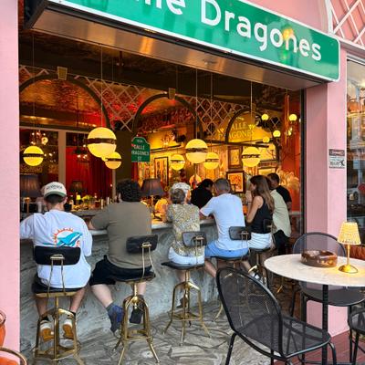 View from outside, you see people seated at the bar enjoying happy hour..
