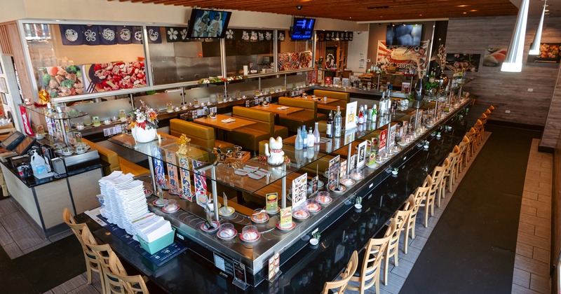 Japanese-style sushi restaurant with a counter with plates of sushi moving along a rotating belt