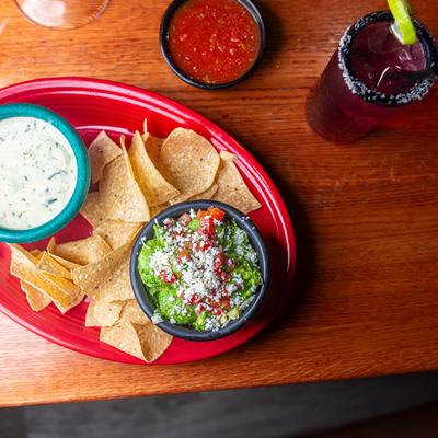 Jalapeno cheese dip and guacamole with tortilla chips.