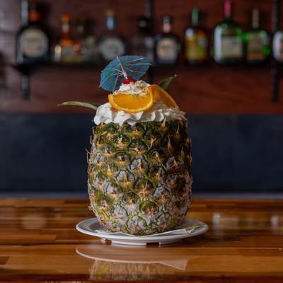 A served cocktail in a whole pineapple.