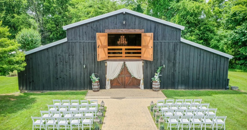 Exterior, wedding ready barn, arranged row seating, yellow brick isle, meticulous lawn