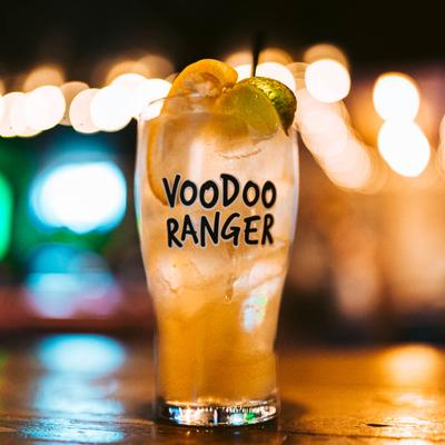 A glass of a drink with the words Voodoo Ranger written on it, garnished with lemon and lime.