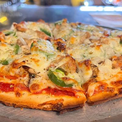 Pizza with chicken, cheese, onions, and jalapenos.