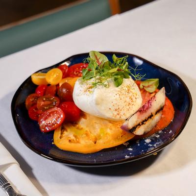 Burrata with heirloom tomatoes, grilled peach, and microgreens.