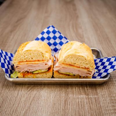 Turkey sandwich with cheese, lettuce, and cucumber.