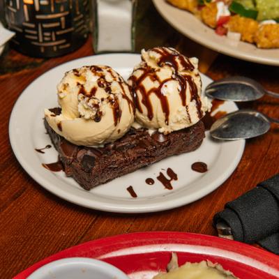 Chocolate Chunkc Brownie topped with ice cream and chocolate sauce.