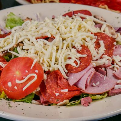 Chef salad with deli meats, shredded cheese, lettuce, and tomato.