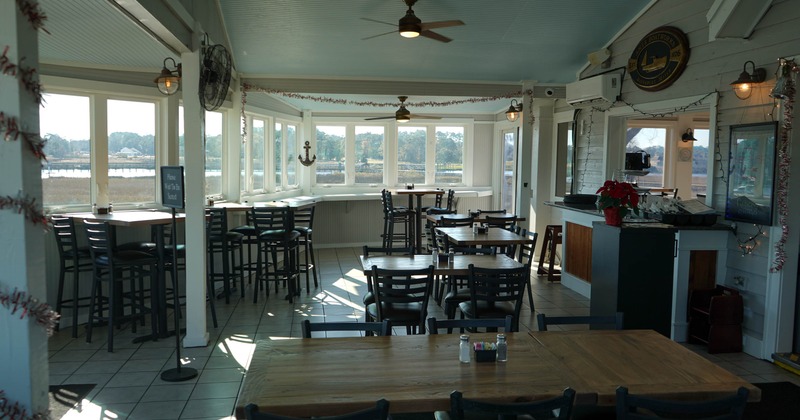 Bright dining area with wooden tables, high windows