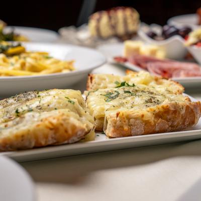 Garlic bread with cheese, assorted dishes behind