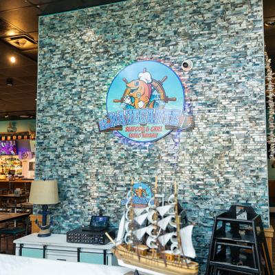 Colorful restaurant sign on blue mosaic tile wall.