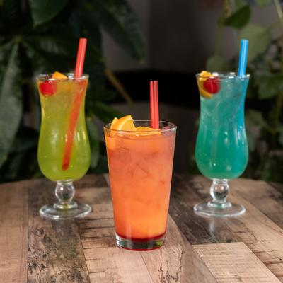 Three colorful cocktails served on a wooden table.