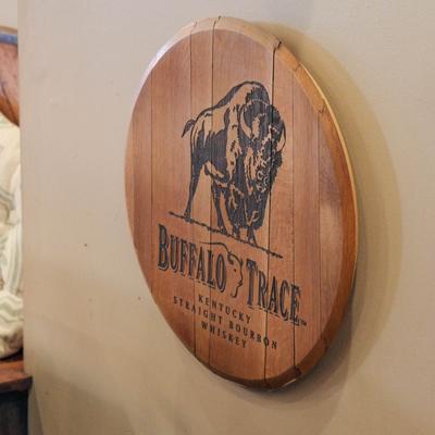 Wooden wall sign with a buffalo illustration mounted indoors.